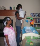 Rashida and Aminah tending to newborn Nicholas