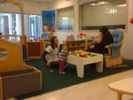 Akilah standing at play table in Infant 2 classroom