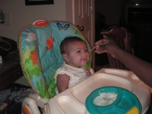 Akilah eating in the high chair
